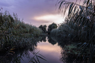 Scenic view of lake against sky at sunset