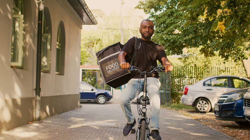 Side view of man riding bicycle on street