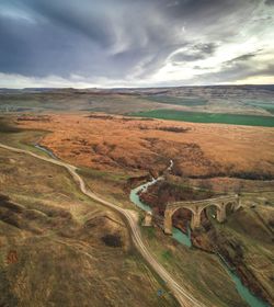 High angle view of road by land against sky