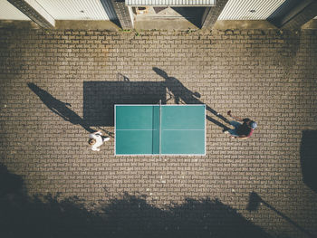 Man with daughter playing table tennis at back yard