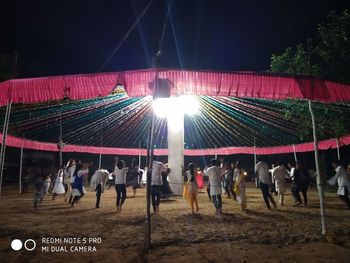 Group of people in illuminated traditional clothing at night