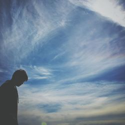 Low angle view of people against cloudy sky