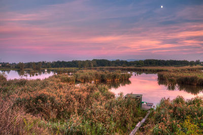 Scenic view of lake against sky at sunset