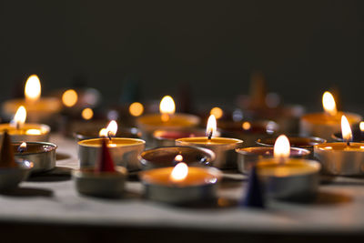 Close-up of lit tea light candles in temple