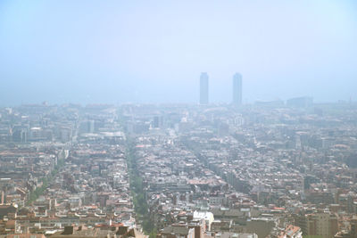 Aerial view of buildings in city against sky