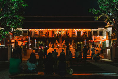 Group of people in illuminated building at night