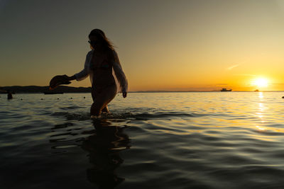 Side view of woman standing in sea