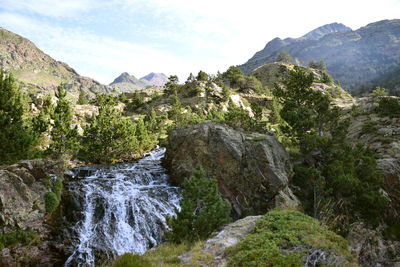 Scenic view of river amidst mountains against sky