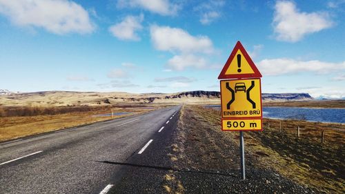 Road sign against sky