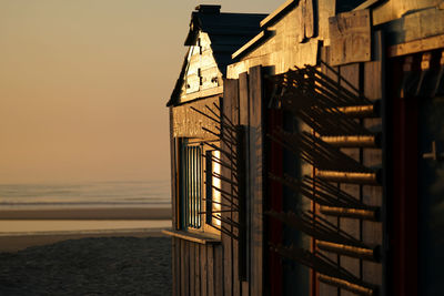 Building by sea against sky during sunset