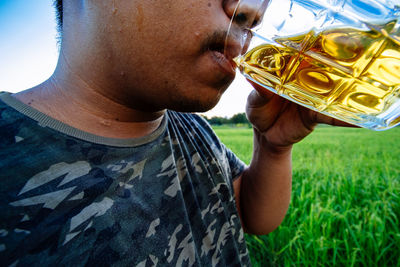 Close-up portrait of a man drinking glass