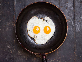 Directly above shot of fried egg in cooking pan on table