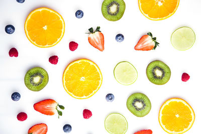 Directly above shot of fruits served on white background