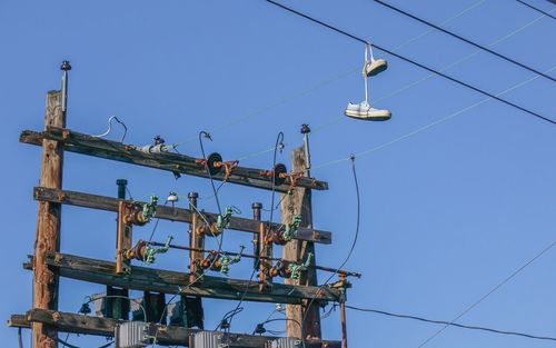 Low angle view of power lines against blue sky