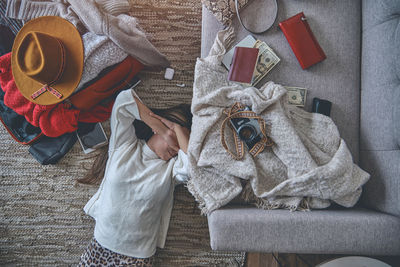 Young woman just arrived in the hotel and relaxing at the floor after a long flight