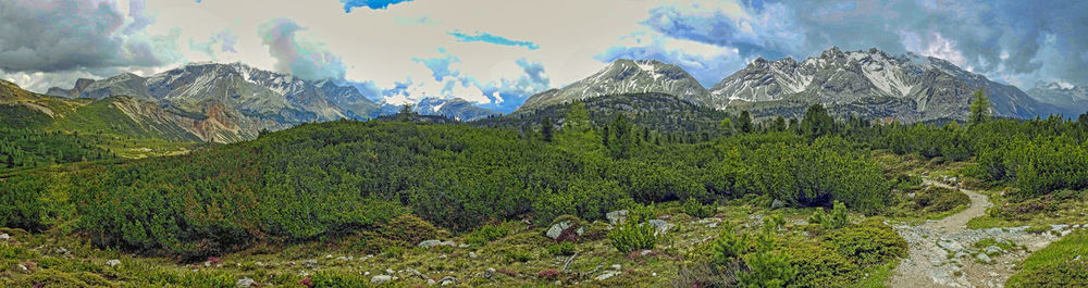 Scenic view of green landscape and mountains against sky