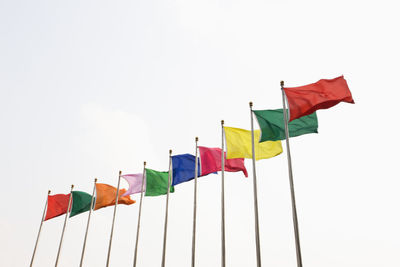 Low angle view of flags against clear sky
