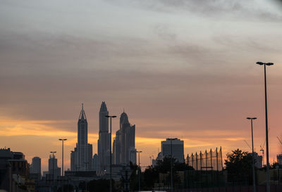 Silhouette of buildings against cloudy sky during sunset