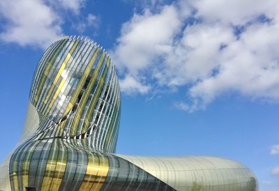 Low angle view of modern building against cloudy sky