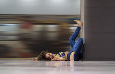 Side view of woman lying down on floor