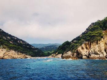 Scenic view of sea and mountains against sky