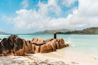 Person on sandy beach, from behind, sea, summer, travel, tropics.