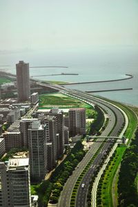 High angle view of city by sea against sky