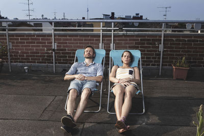 Germany, berlin, couple relaxing on roof terrace