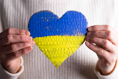 Midsection of woman holding heart shape