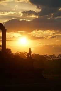 Silhouette man statue against sky during sunset