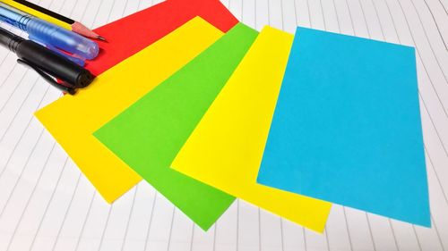 High angle view of multi colored pencils on paper