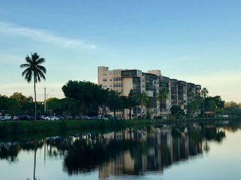Reflection of palm trees and buildings in lake