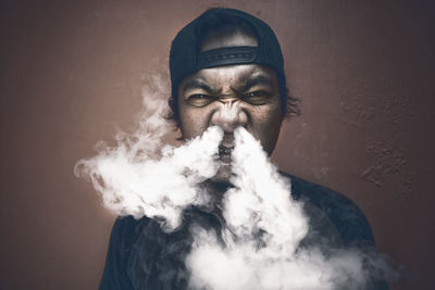 Portrait of young man smoking outdoors