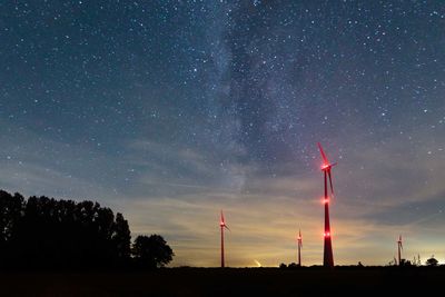 Illuminated windmills against star field