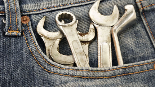 Close-up of tools in blue jeans 