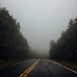 Road amidst trees against sky