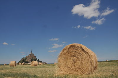 Hay bales on field against sky