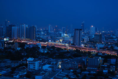 Illuminated buildings in city against sky at night