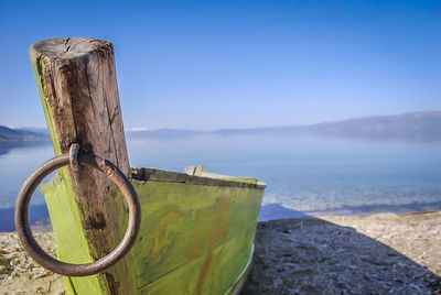 Close-up of wooden post at beach against sky