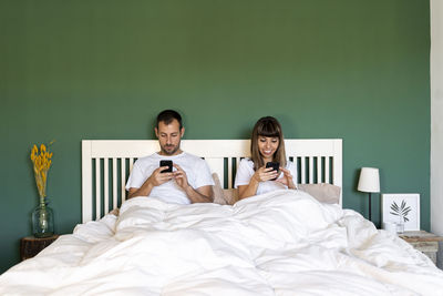 Young couple sitting on bed