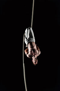 Person holding rope against black background