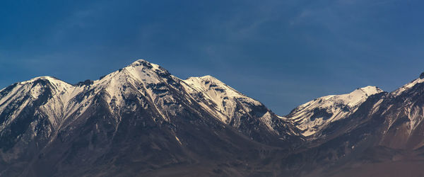 Low angle view of snowcapped mountains against sky