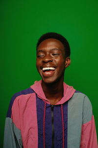 Portrait of young man standing against blue background