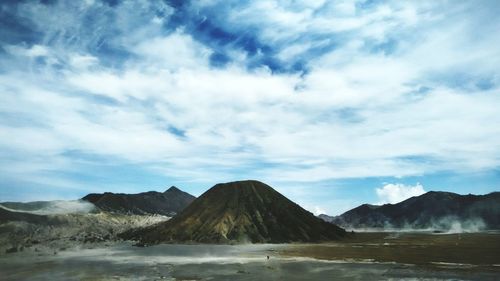 Scenic view of mountains against cloudy sky