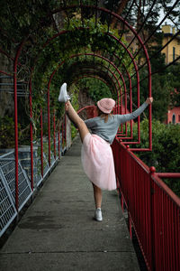 Rear view of woman standing on footbridge