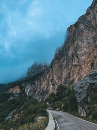 Road amidst rocks against sky