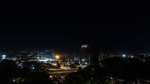 Illuminated cityscape against sky at night