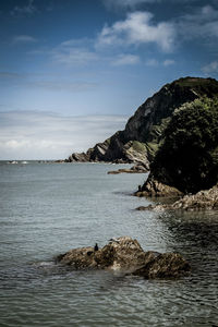 Scenic view of rocks in sea against sky