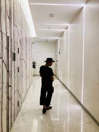 Rear view of man walking in corridor of building