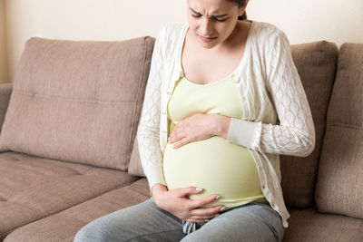 Woman sitting on sofa at home